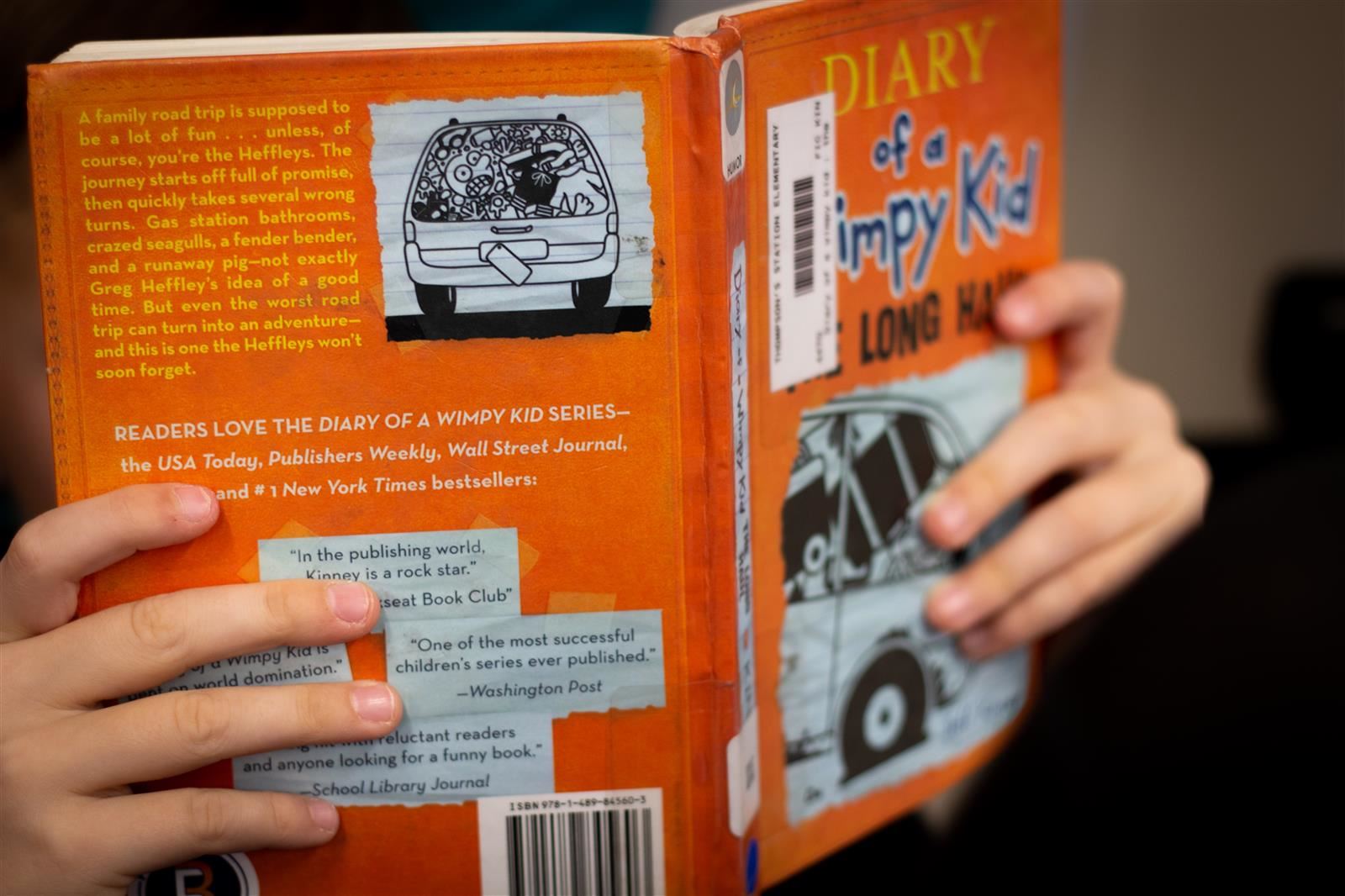 Student holding a book up.